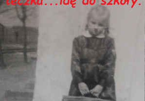 Zdjęcie uczennicy Krystyny Hamery (Jędrzejek) na tle budynku domu kolejowego wraz z opisem - Fartuszek z biały kołnierzykiem, tarcza na rękawie, teczka... idę do szkoły.